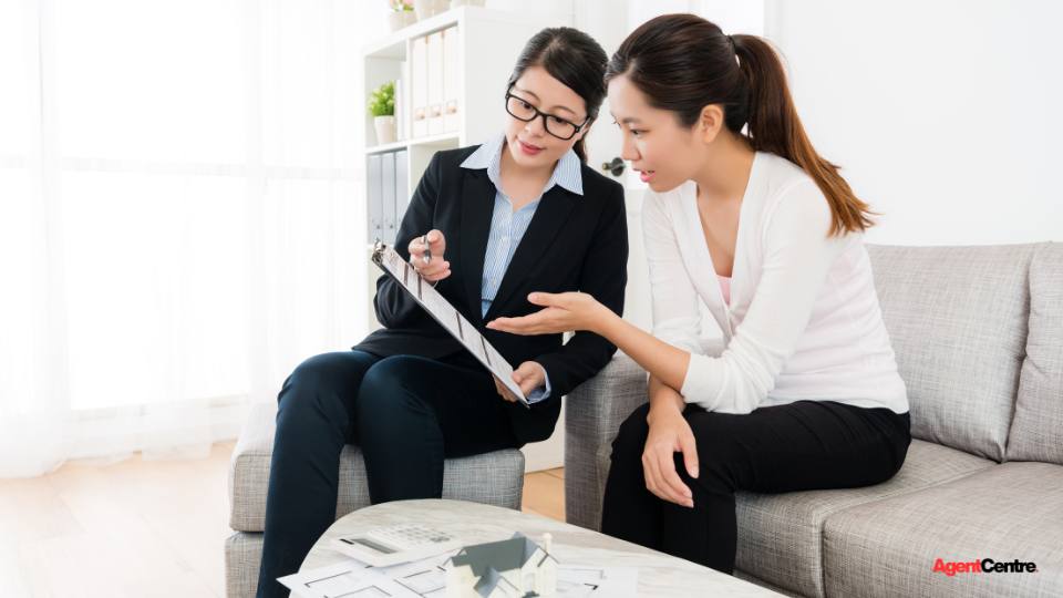 A buyers agent reviewing property plans with a family